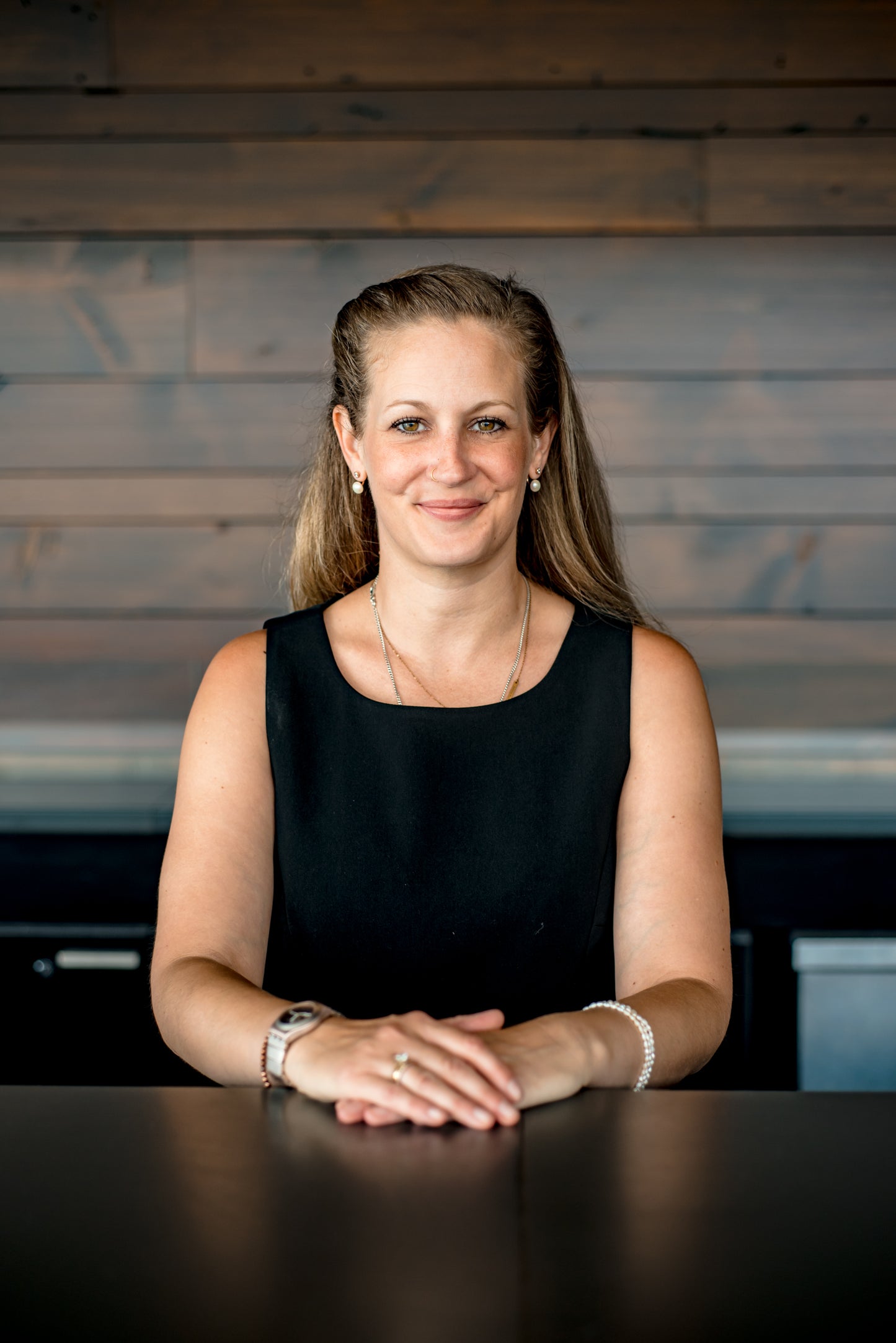 A woman sits at a desk, posing to represent her new business